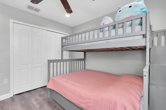 bedroom with light hardwood / wood-style floors, a closet, and ceiling fan