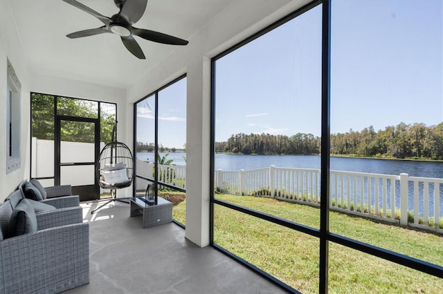 sunroom with a water view and ceiling fan