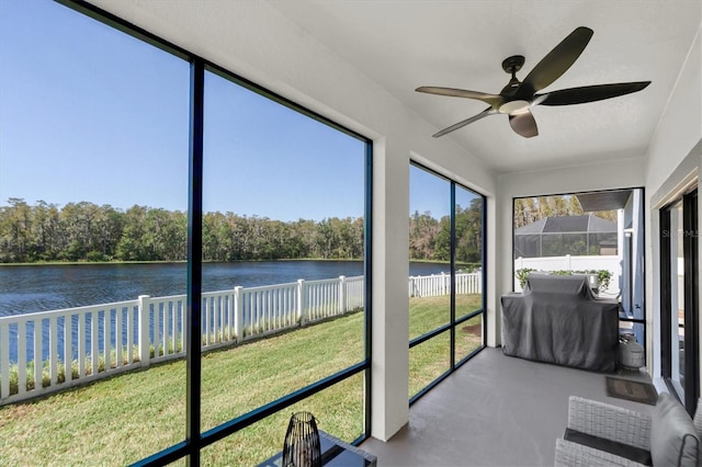 sunroom featuring a water view and ceiling fan