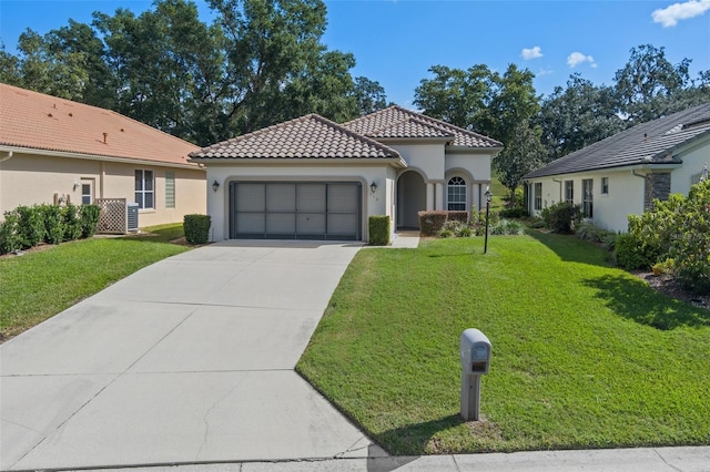 mediterranean / spanish home featuring a garage and a front lawn