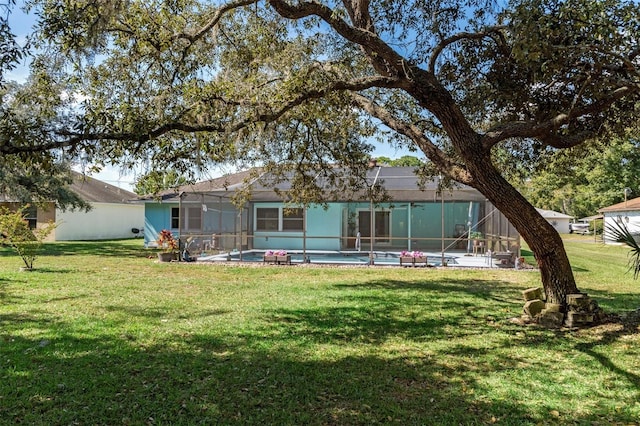 back of house with a yard, a patio area, and glass enclosure