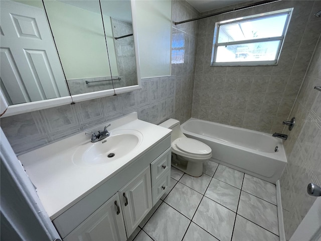 full bathroom featuring tiled shower / bath, tile walls, toilet, vanity, and tile patterned flooring