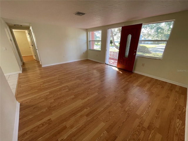 entrance foyer featuring light hardwood / wood-style floors and a textured ceiling