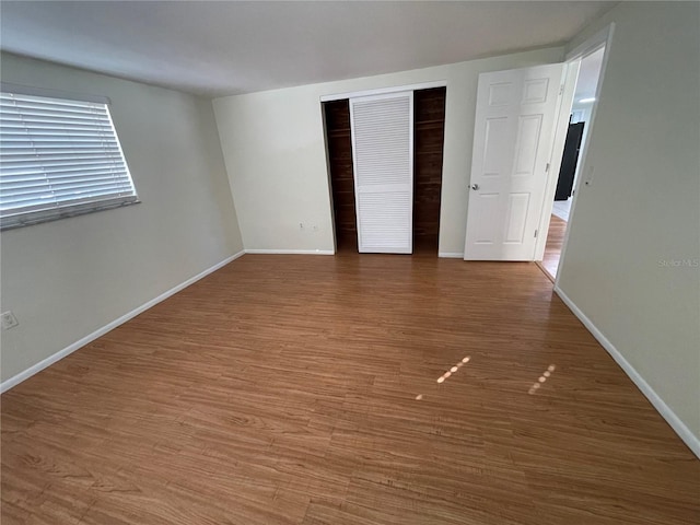 unfurnished bedroom with a closet and hardwood / wood-style flooring