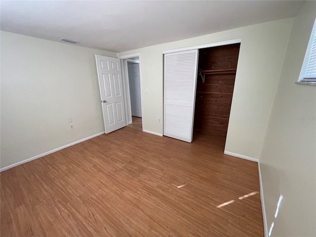 unfurnished bedroom with a closet and wood-type flooring