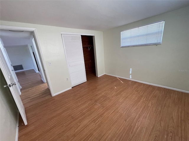 unfurnished bedroom featuring a closet and wood-type flooring