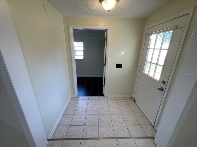 entryway with a textured ceiling and light tile patterned floors