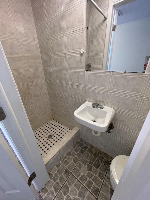 bathroom featuring tile walls, curtained shower, and toilet