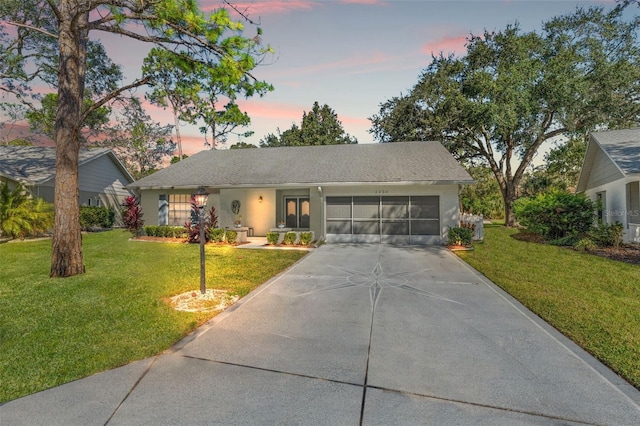 ranch-style home featuring a yard and a garage