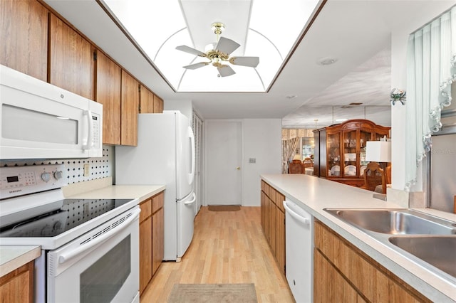 kitchen with white appliances, sink, light hardwood / wood-style floors, ceiling fan, and decorative backsplash