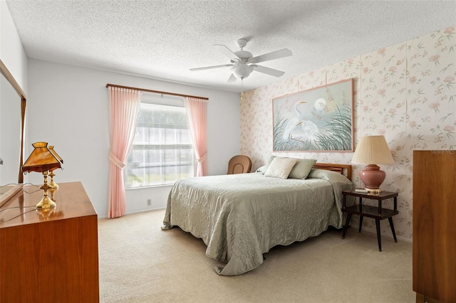 bedroom featuring ceiling fan, a textured ceiling, and light colored carpet