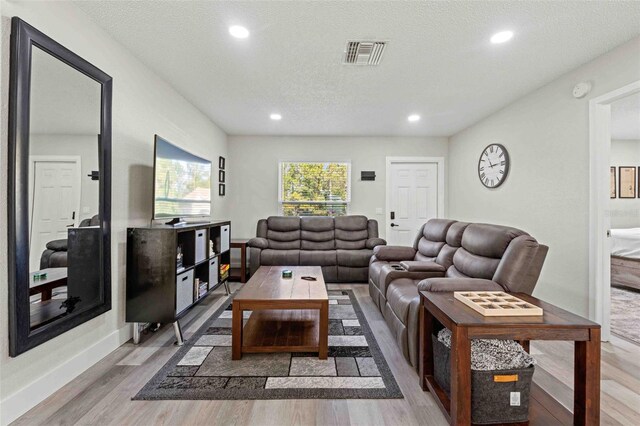 living room with wood-type flooring and a textured ceiling