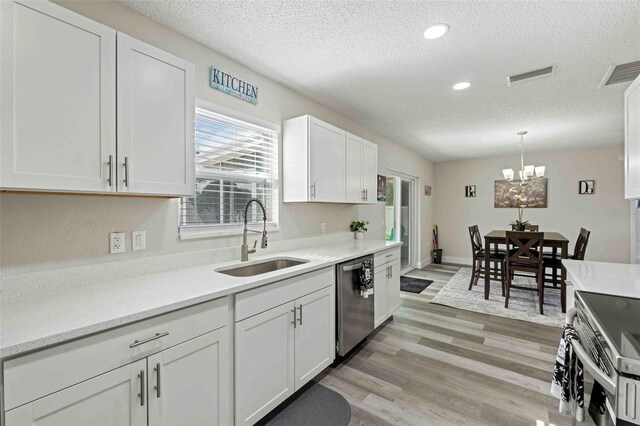 kitchen with white cabinets, sink, light wood-type flooring, and stainless steel appliances