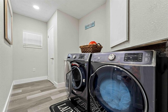 clothes washing area with light hardwood / wood-style floors and independent washer and dryer