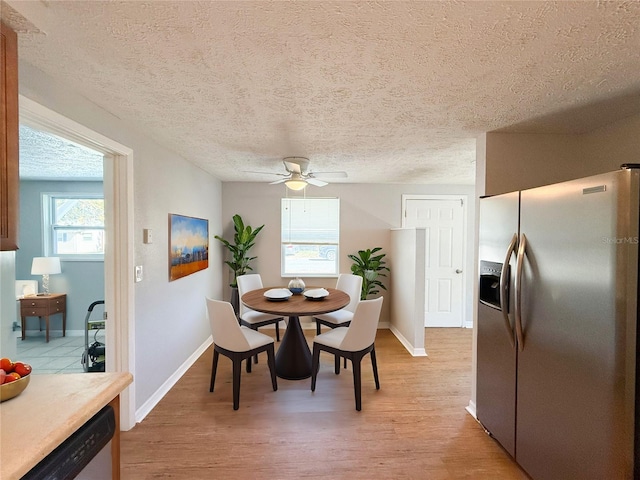 dining area featuring a textured ceiling, ceiling fan, and light hardwood / wood-style flooring