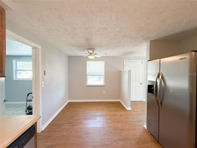 kitchen featuring a textured ceiling, stainless steel appliances, ceiling fan, and light hardwood / wood-style flooring