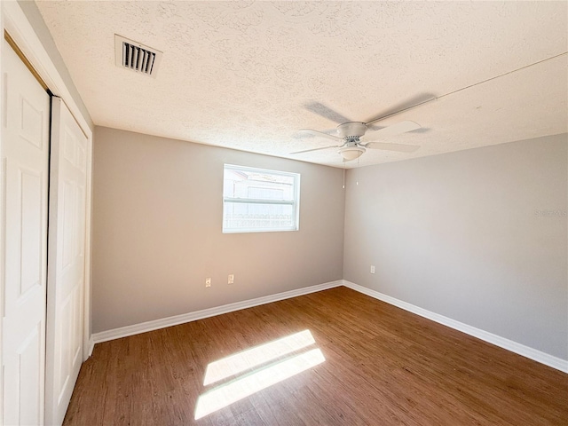 unfurnished bedroom featuring a textured ceiling, wood-type flooring, and ceiling fan