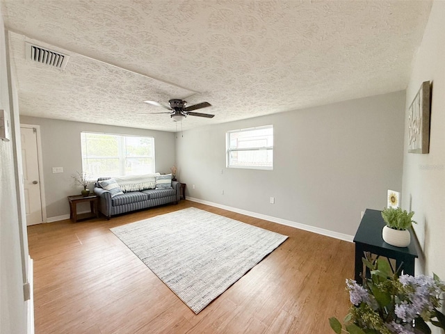 4041 Las Vegas Dr, New Port Richey, FL 34653 - living area with a textured ceiling, plenty of natural light, wood finished floors, ceiling fan, and baseboards