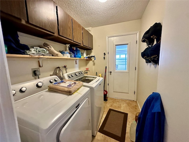 laundry area featuring cabinets, a textured ceiling, and separate washer and dryer