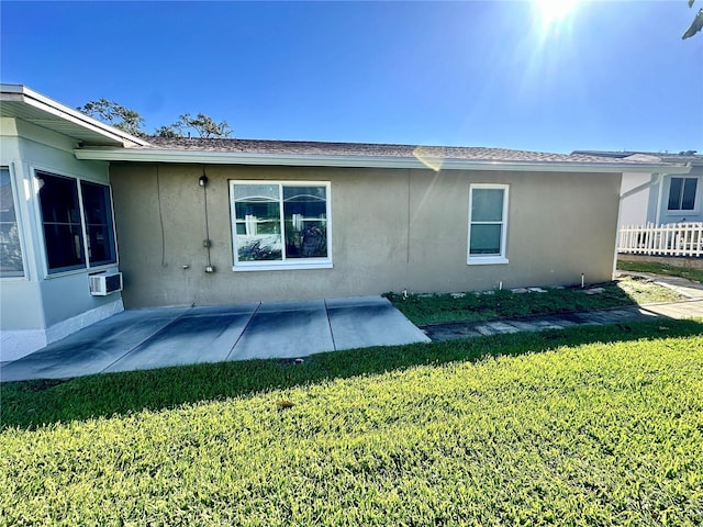 back of property with a patio area and a lawn