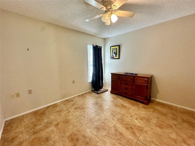 unfurnished bedroom featuring light tile patterned flooring, a textured ceiling, a ceiling fan, and baseboards