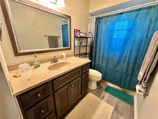 full bathroom with toilet, a shower with curtain, wood finished floors, and vanity