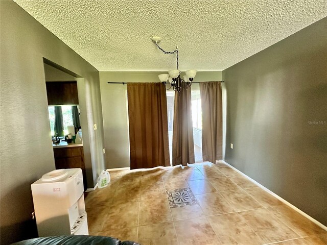 10521 Mira Vista Dr, Port Richey, FL 34668 - unfurnished dining area with a chandelier, a textured ceiling, tile patterned floors, and baseboards