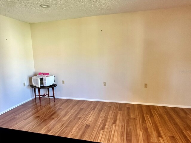 10521 Mira Vista Dr, Port Richey, FL 34668 - empty room featuring wood finished floors, baseboards, and a textured ceiling