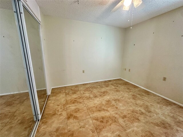 10521 Mira Vista Dr, Port Richey, FL 34668 - unfurnished bedroom with a textured ceiling, ceiling fan, a closet, and light tile patterned flooring
