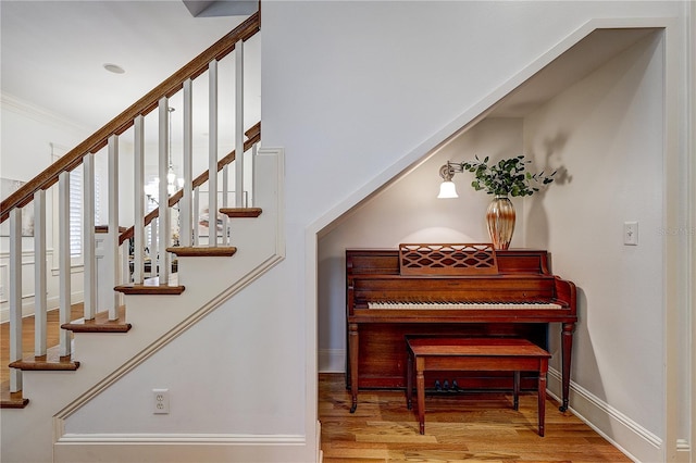 stairs featuring hardwood / wood-style floors and ornamental molding