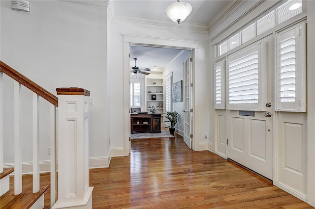 foyer with light hardwood / wood-style flooring, ceiling fan, and ornamental molding