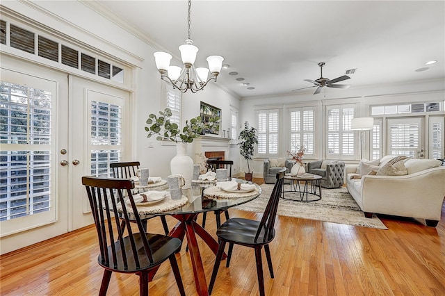 dining area with light hardwood / wood-style flooring, crown molding, plenty of natural light, and french doors