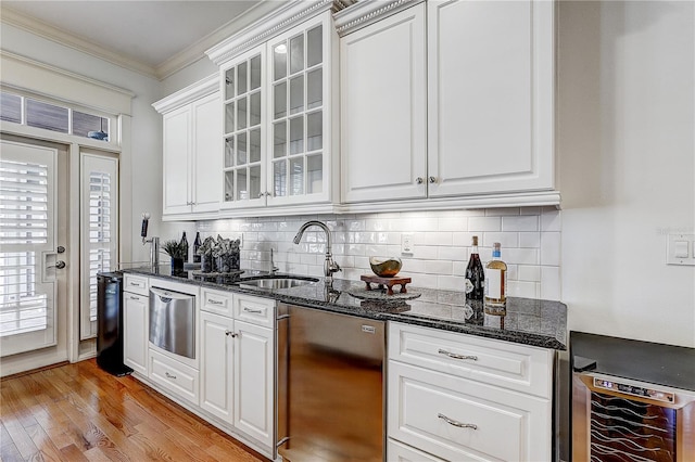 kitchen with refrigerator, wine cooler, sink, ornamental molding, and white cabinets