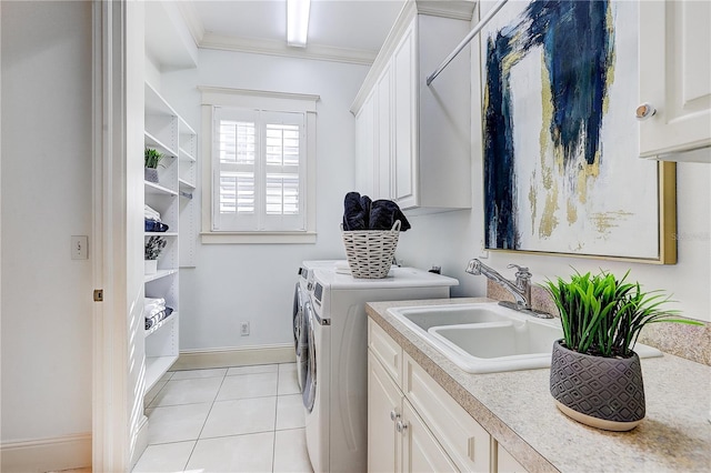 washroom featuring washing machine and dryer, crown molding, light tile patterned floors, sink, and cabinets