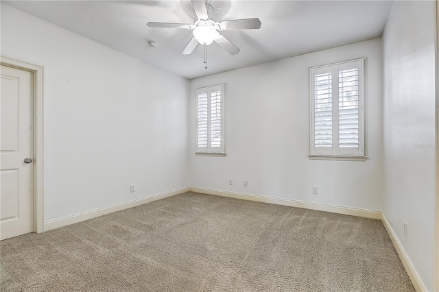 carpeted spare room featuring ceiling fan