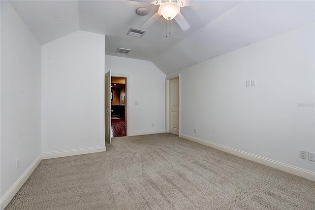 carpeted spare room with vaulted ceiling and ceiling fan