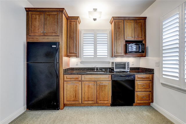 kitchen with light carpet, dark stone countertops, sink, and black appliances