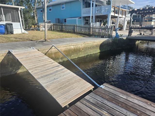 dock area featuring a water view and a lawn