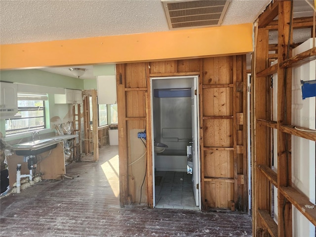 misc room featuring wood walls and a textured ceiling