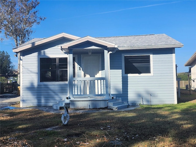 view of front of house with a front yard and a porch