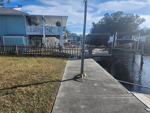 dock area featuring a lawn and a water view