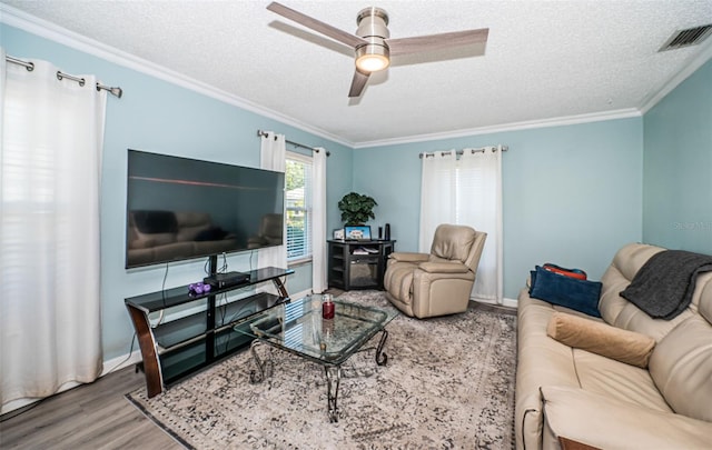 living room featuring ceiling fan, crown molding, a textured ceiling, and hardwood / wood-style floors