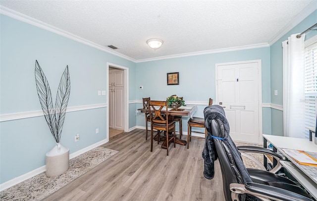 office space with light hardwood / wood-style flooring, a textured ceiling, and crown molding