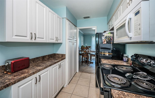 kitchen featuring black range with electric stovetop, white cabinetry, light wood-type flooring, and dark stone countertops