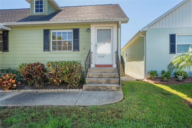 entrance to property with a lawn