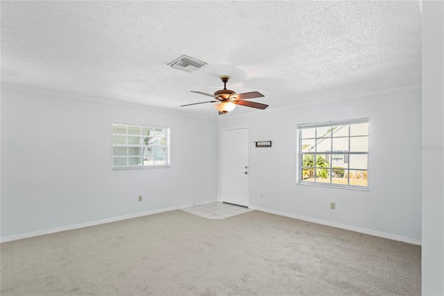 carpeted empty room featuring ceiling fan, a textured ceiling, and ornamental molding