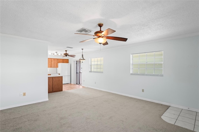 unfurnished living room with light carpet, a textured ceiling, and crown molding