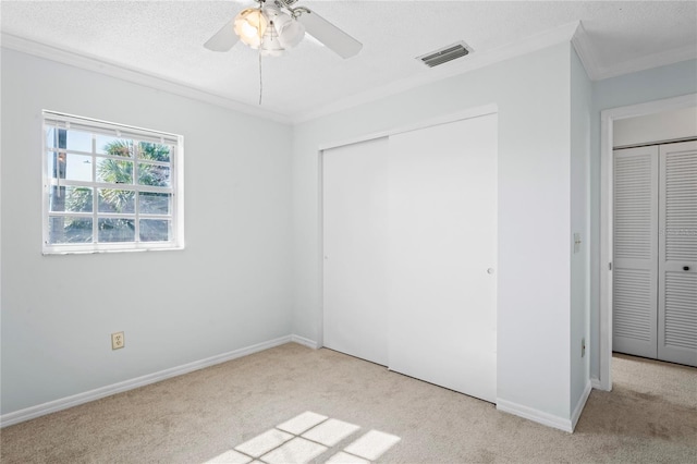 unfurnished bedroom with light carpet, a closet, ceiling fan, and ornamental molding