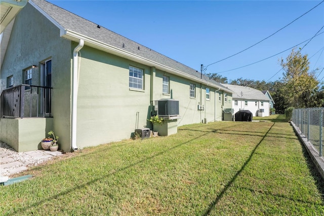 view of side of property with a lawn and central AC unit