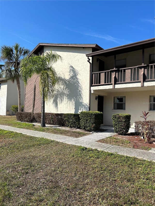 view of home's exterior featuring a yard and a balcony